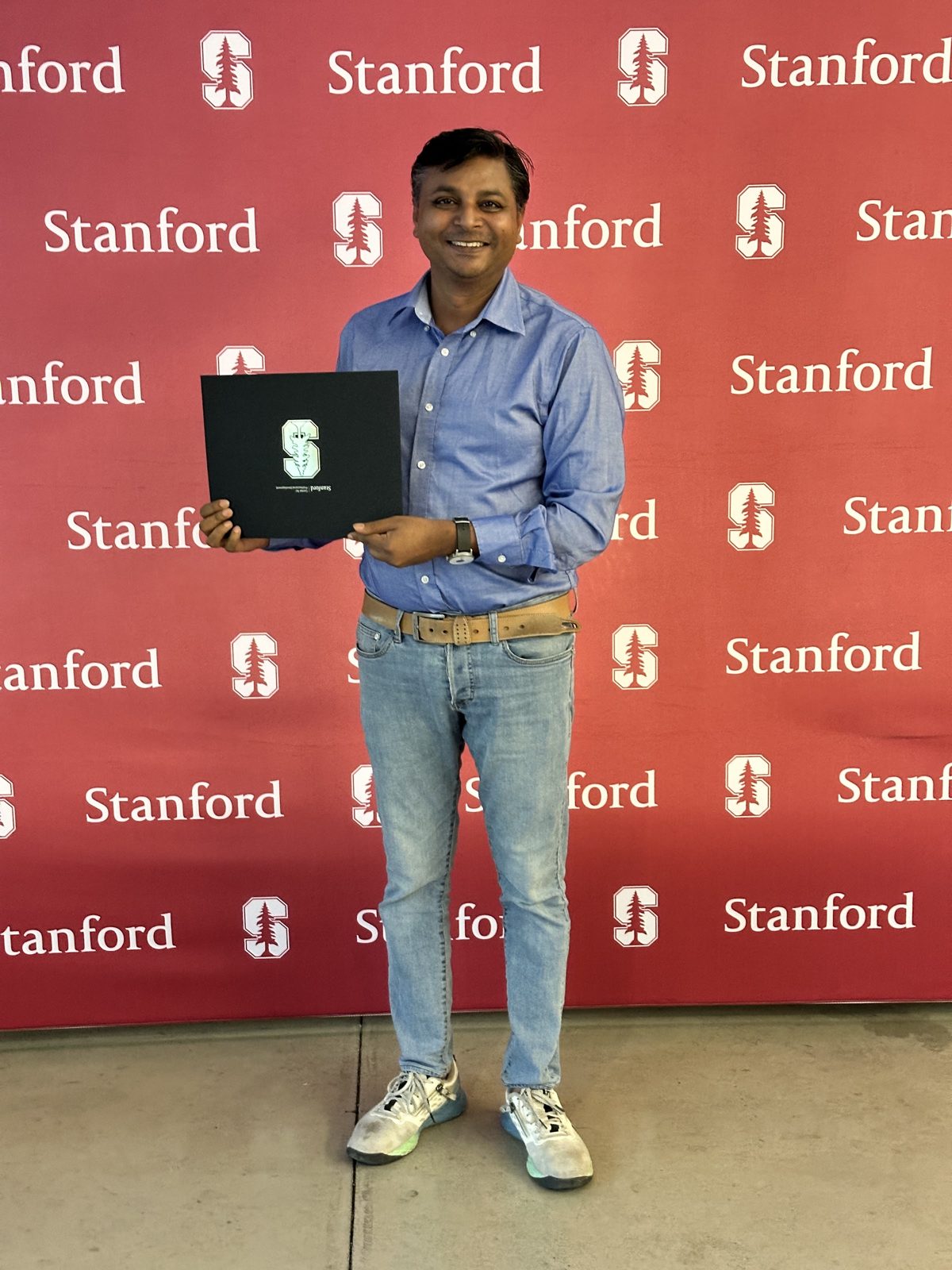 Vivek Kumar holding his Stanford Innovation and Entrepreneurship Professional Certificate at Stanford University